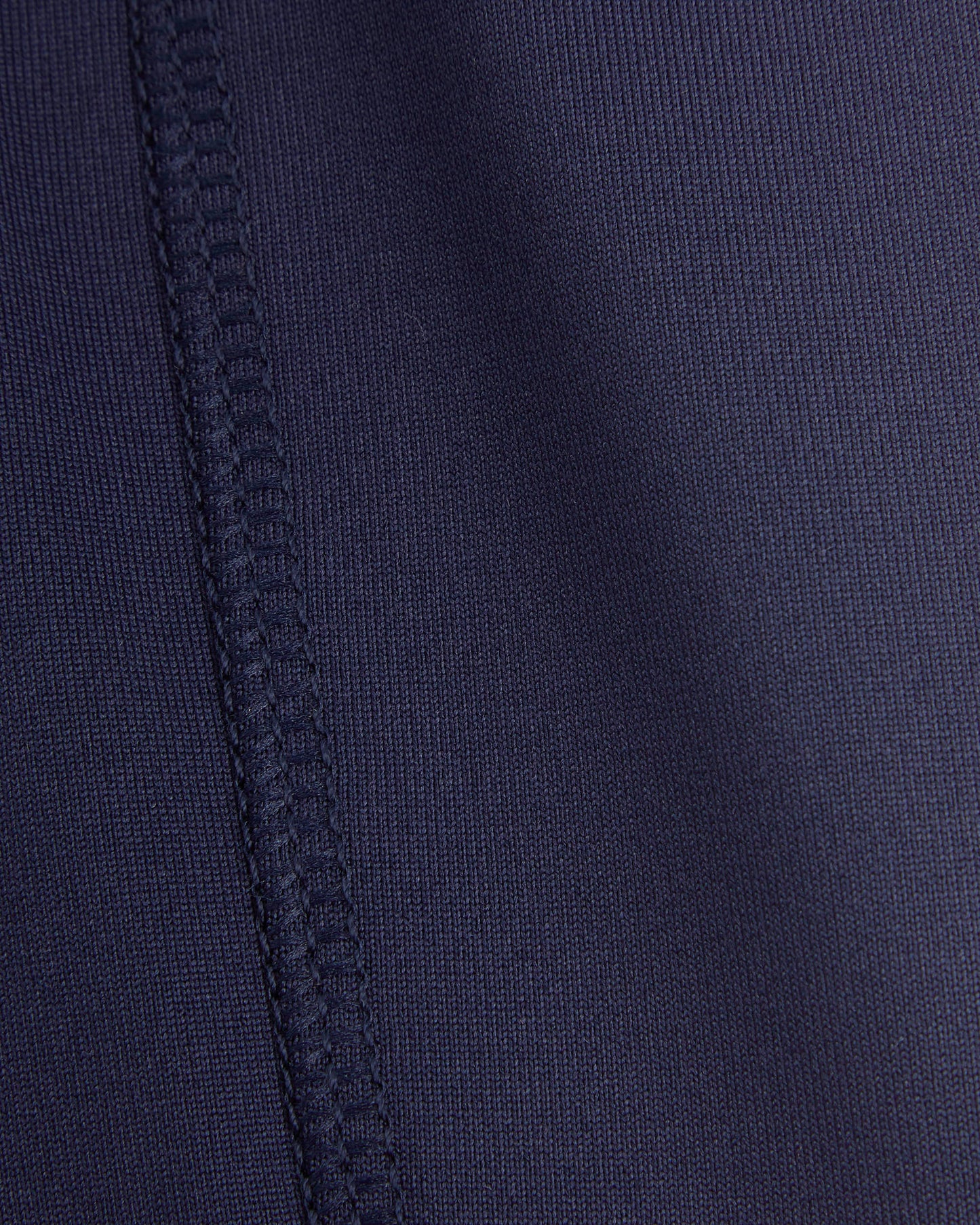Close-up of a navy blue fabric with stitching detail