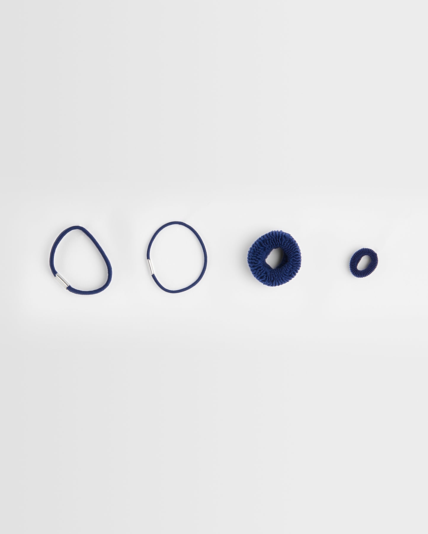 Set of navy hair ties on a light grey background
