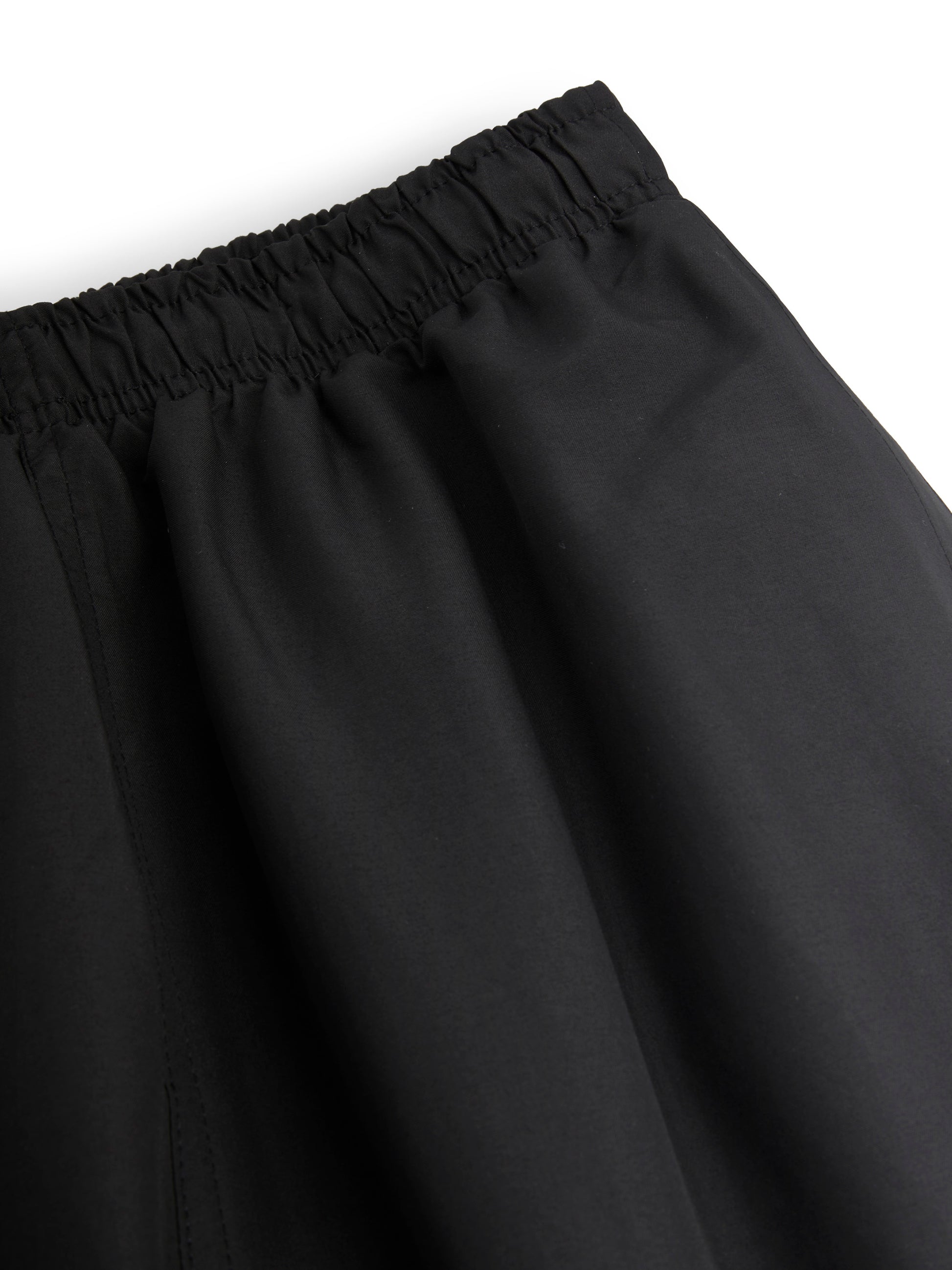 Black track pants with an elastic waistband on a white background