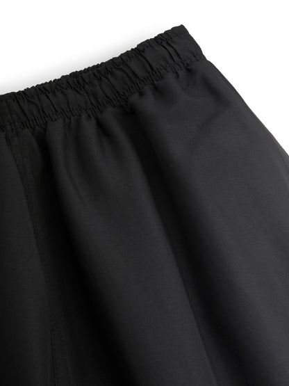 Black track pants with an elastic waistband on a white background