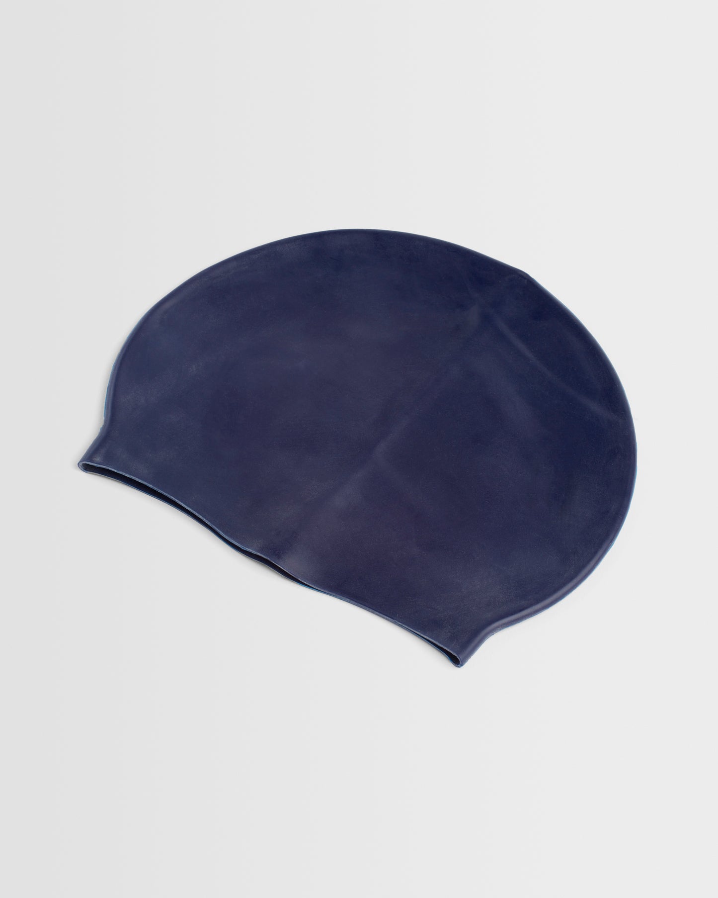A navy silicone swim cap placed on a white background.