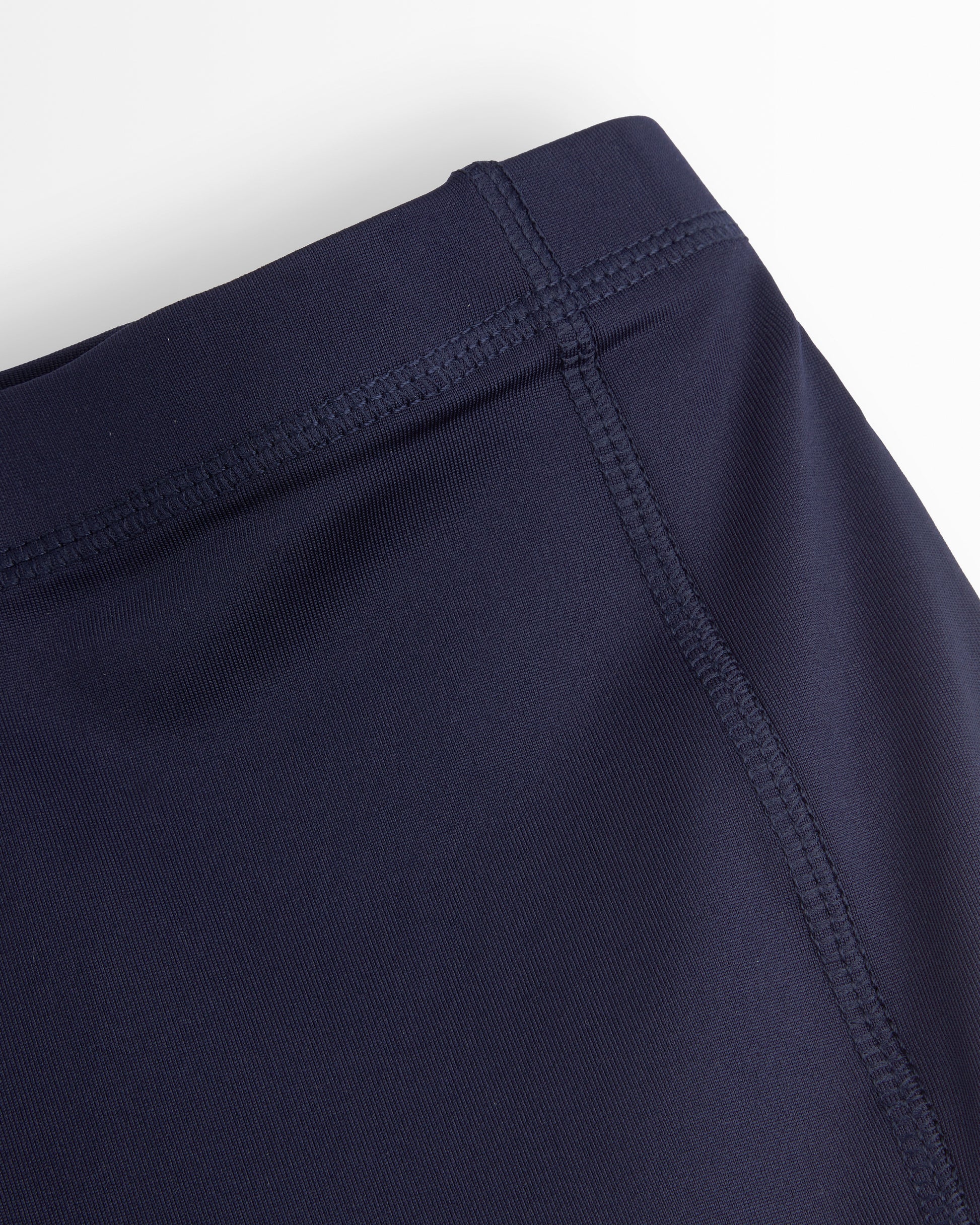 Navy blue shorts with a close-up of the waistband on a white background