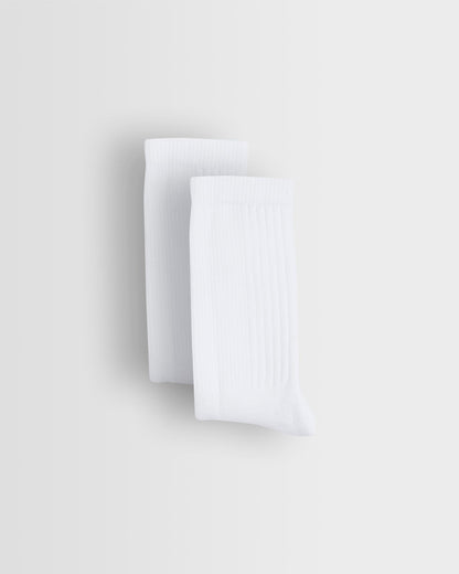 Two white sports socks stacked on top of each other against a light background.