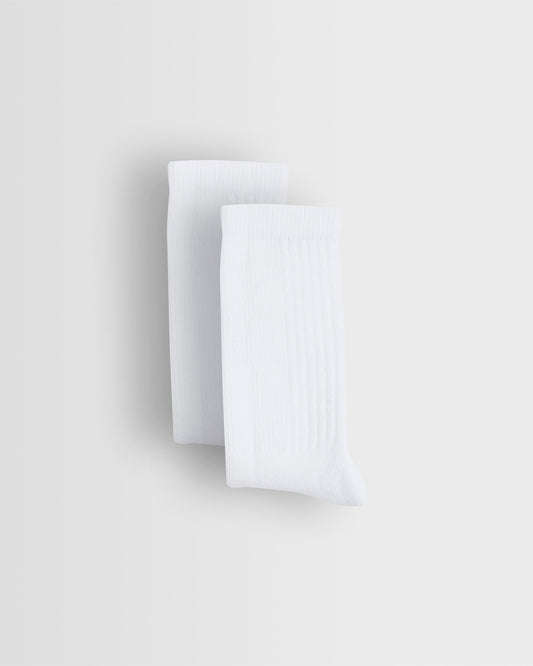 Two white sports socks stacked on top of each other against a light background.