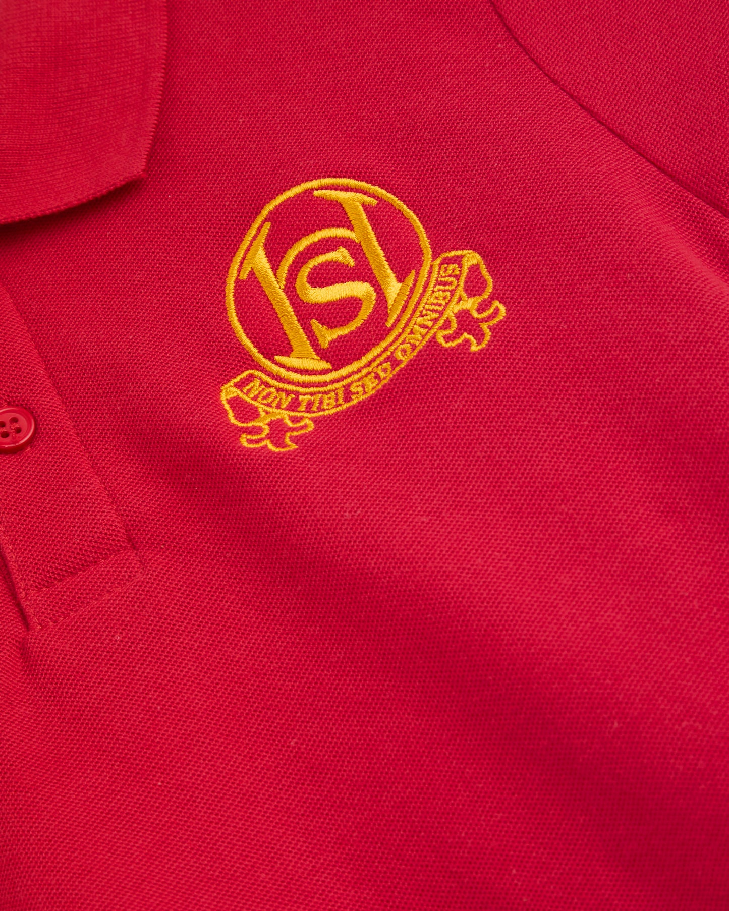 Close-up of a red polo shirt with a yellow logo