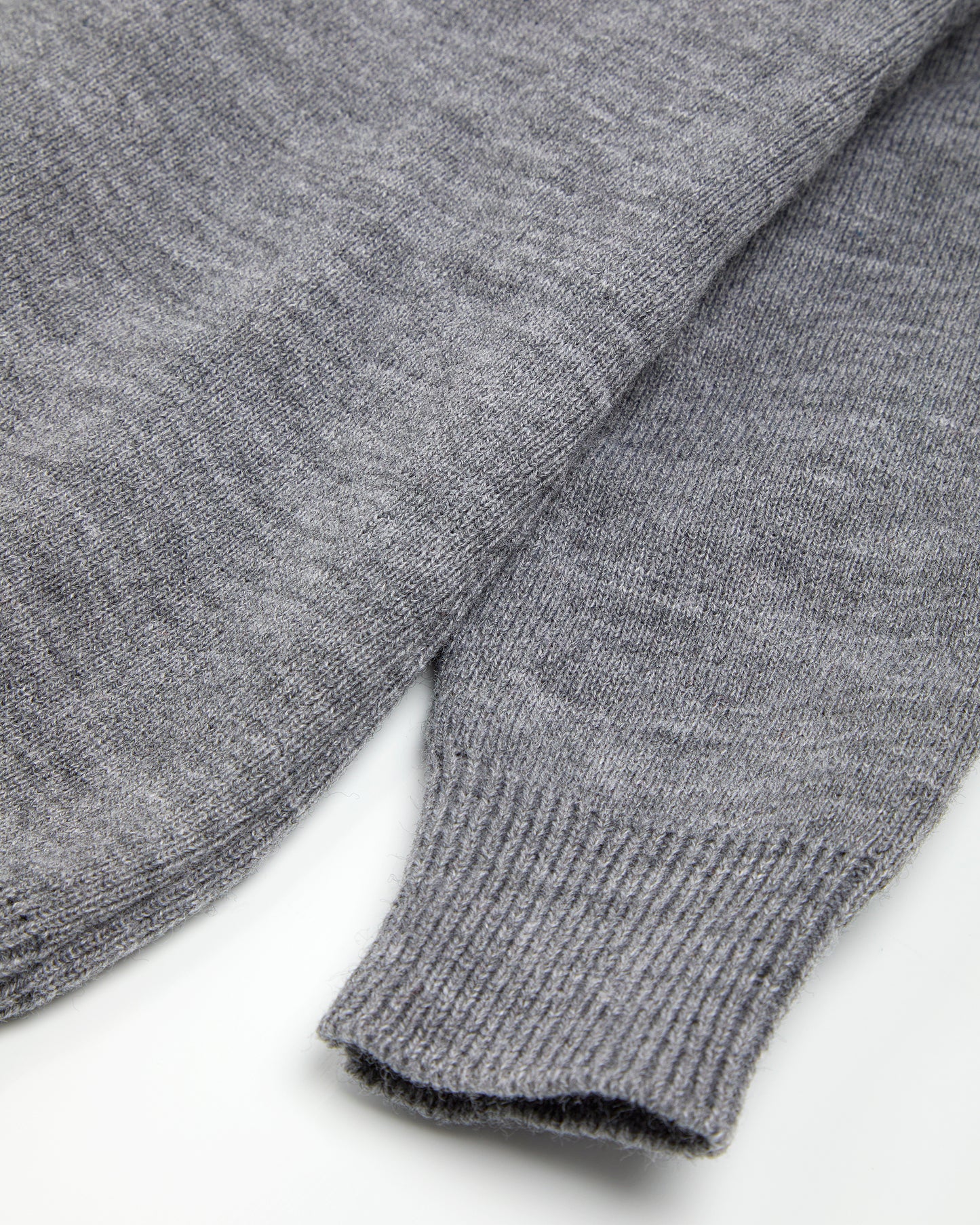 Close up of ribbed cuff on a grey unisex pullover.