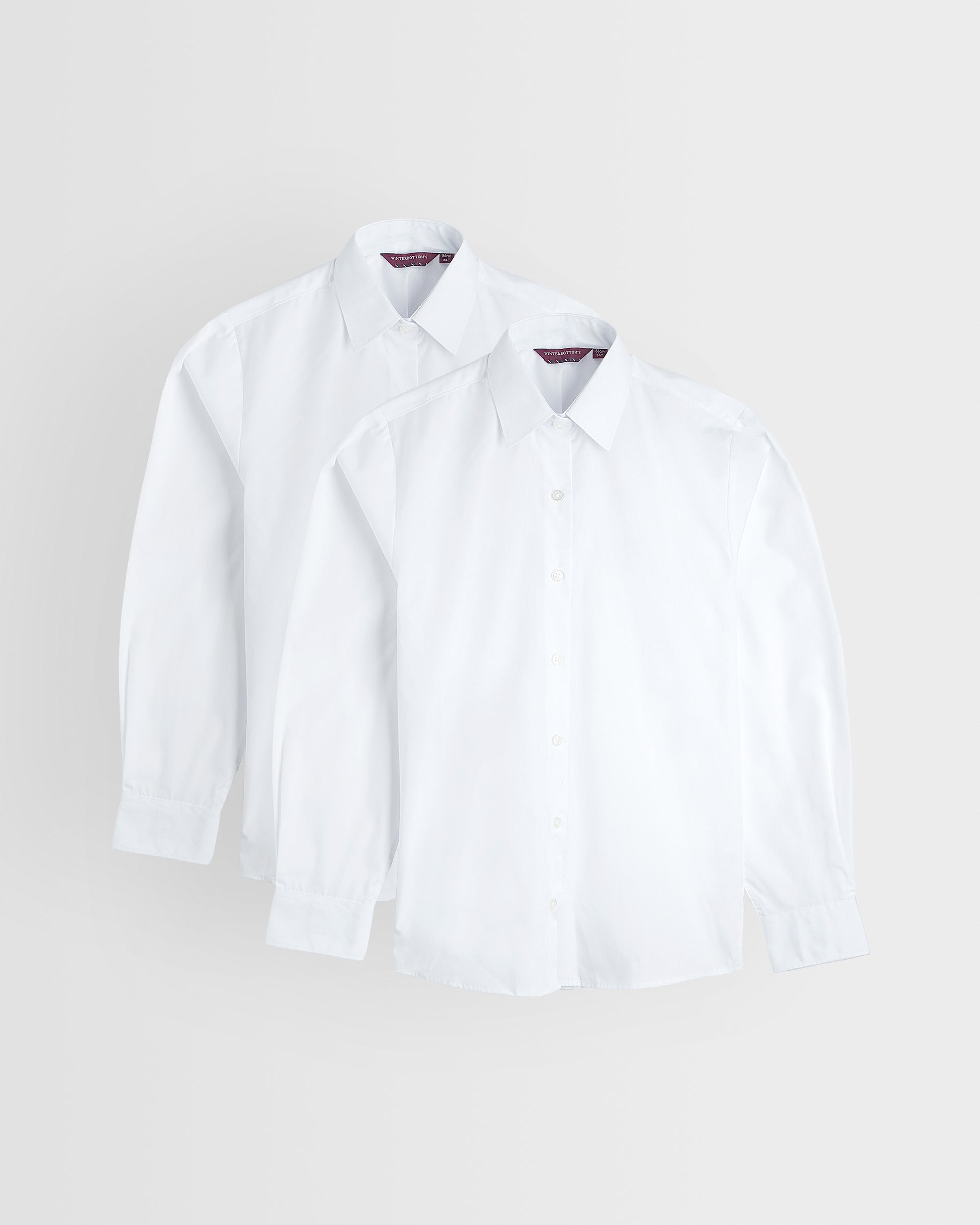 Two white long sleeve shirts laid out flat on a white background, standard collar, buttoned to the neck.