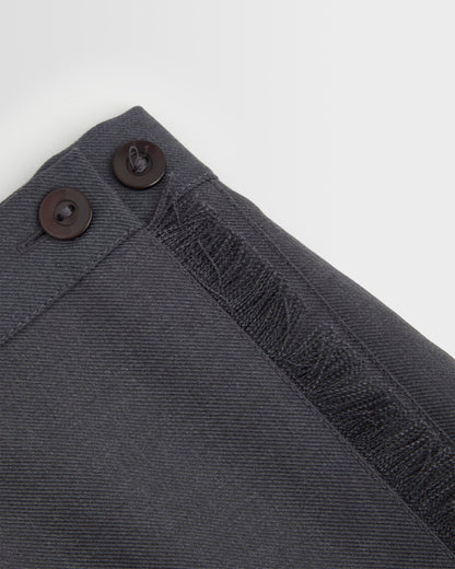 Close up of button and edge detail on girls grey kilt