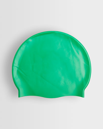 A green silicone swimming cap placed on a white background.