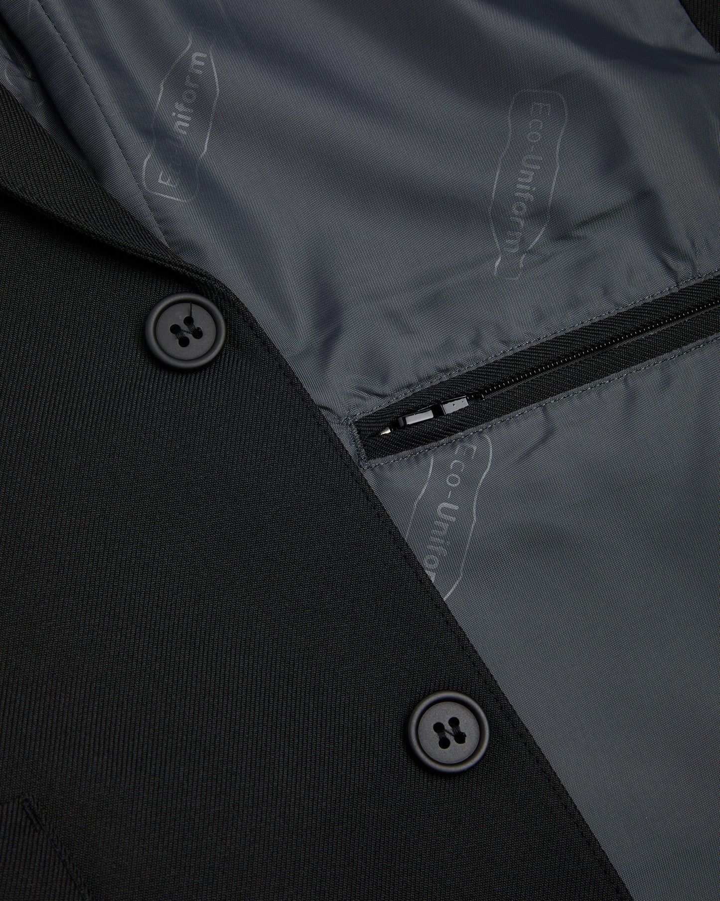 Boys black blazer showing inside zipped pocket and two black external buttons