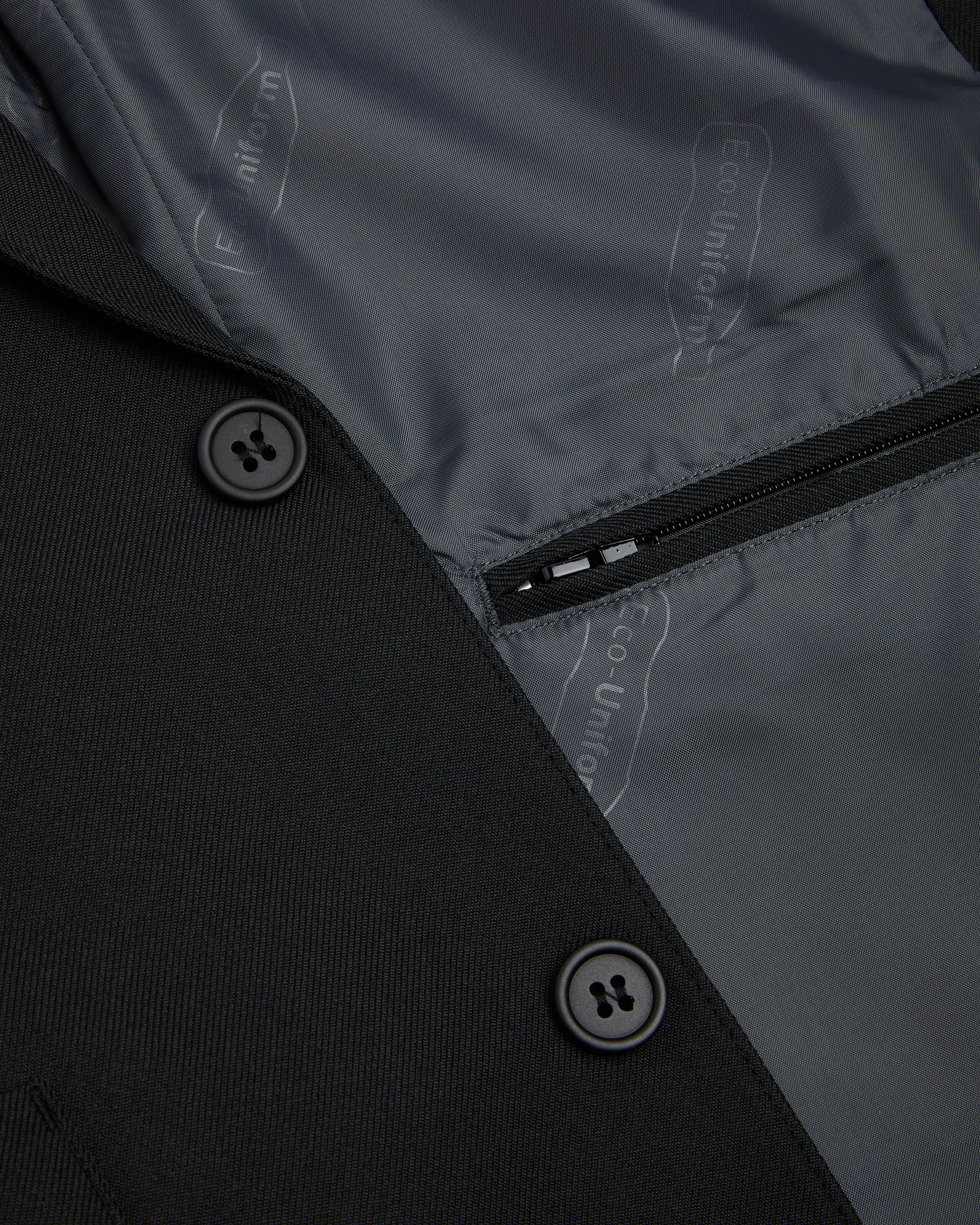 Boys black blazer showing inside zipped pocket and two black external buttons