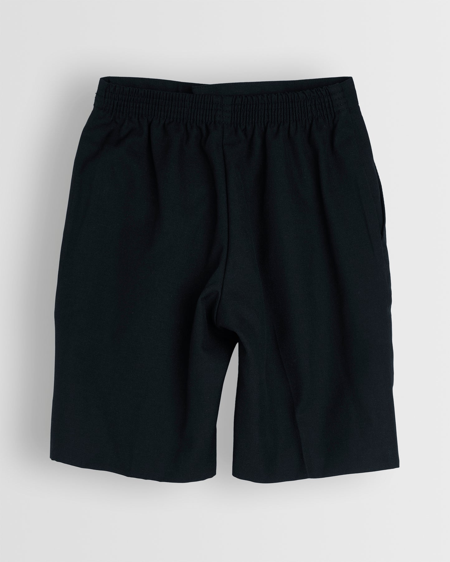 Back view of boys navy summer shorts with a half elasticated waist and single hook and bar fastening, waist size in inches, fully lined, no belt loops.