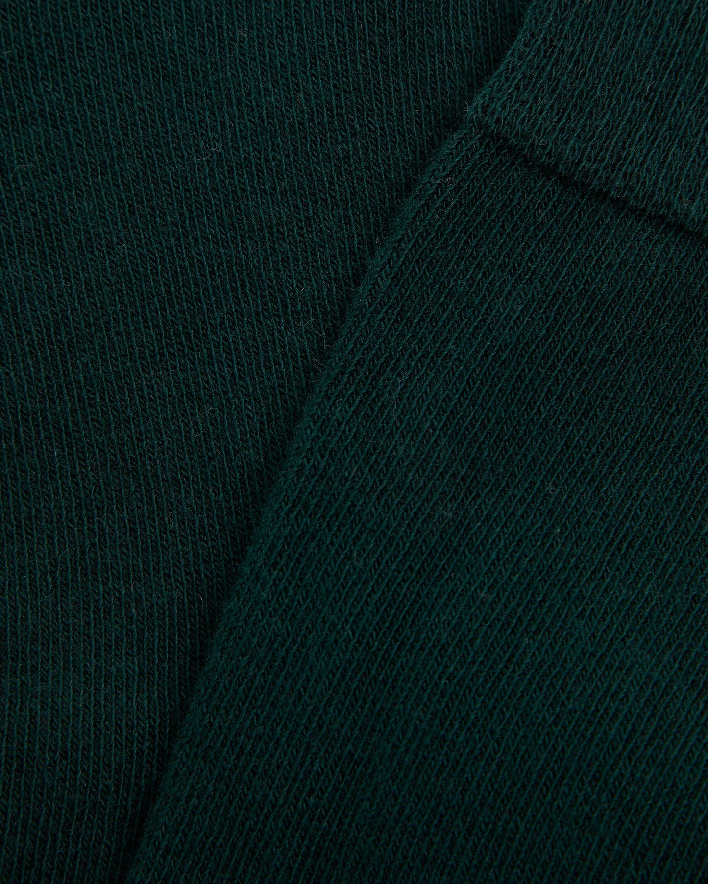 Close up of a single green long sock against a white background, designed for girls.