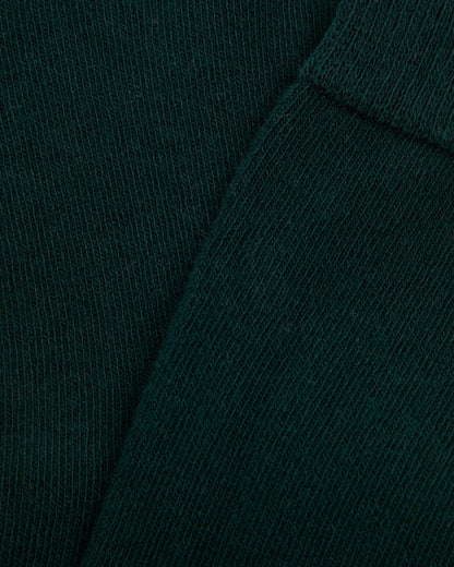 Close up of a single green long sock against a white background, designed for girls.