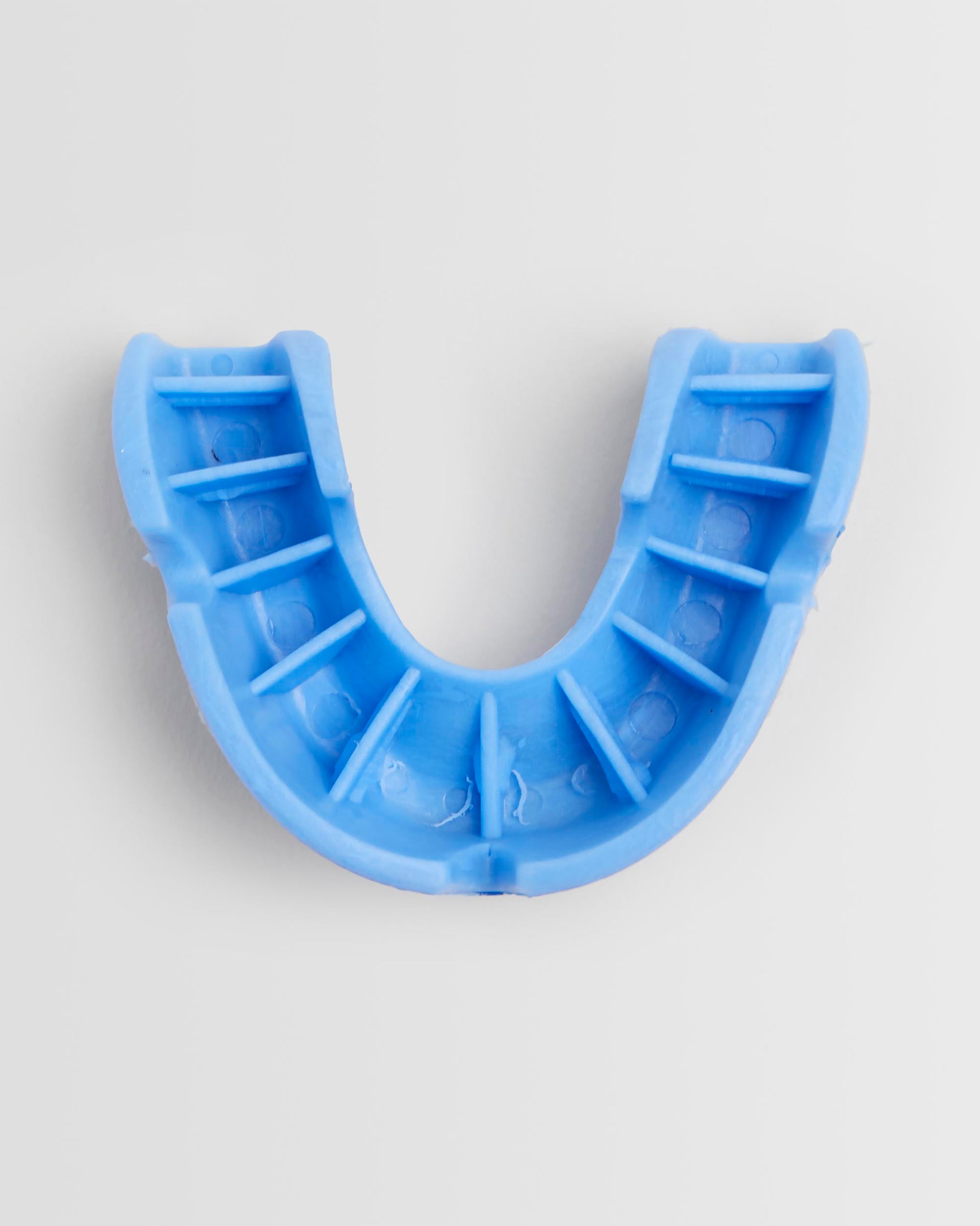 Top view of a blue OPRO mouthguard and its packaging on a white background.