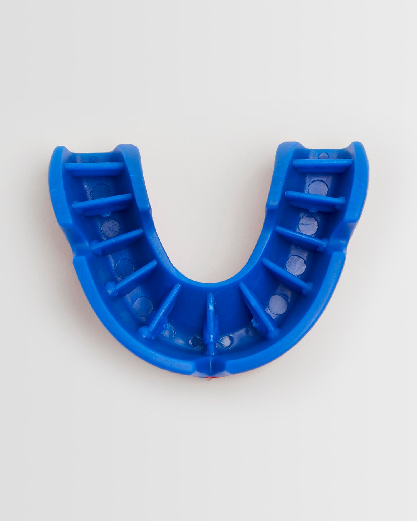 Top view of a red/blue OPRO mouthguard and its packaging on a white background.
