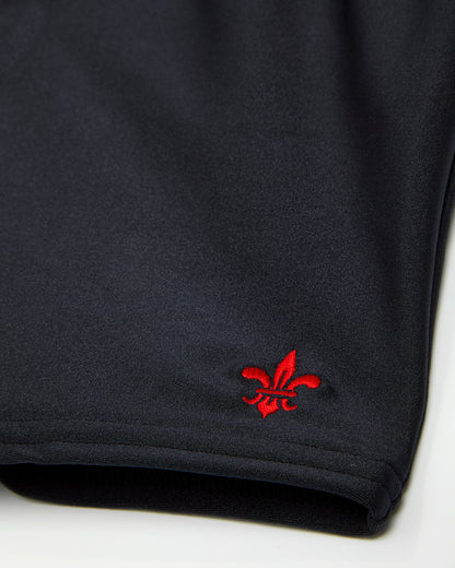 Close up of logo on right leg of black swimming jammers